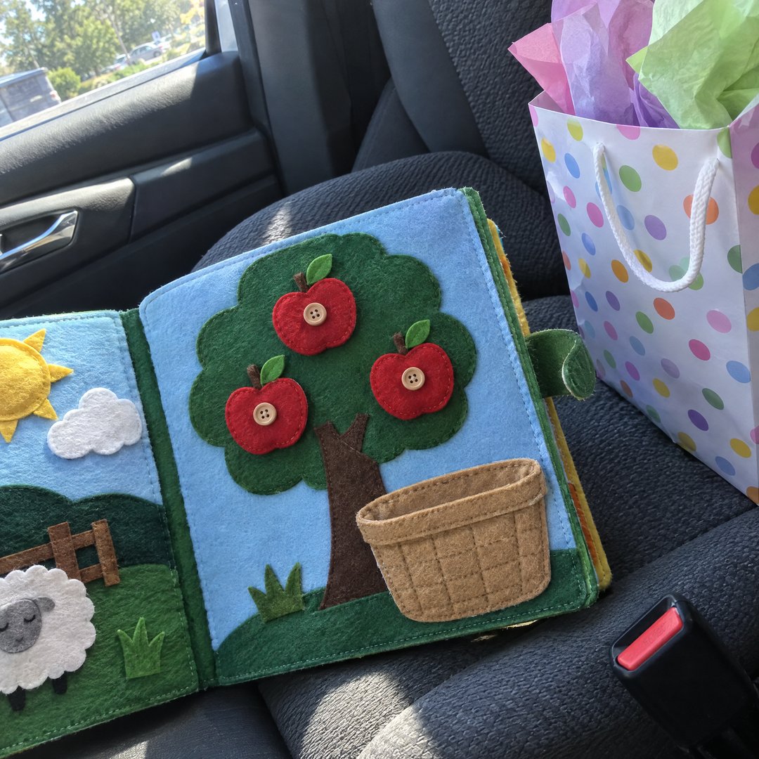 A finished felt quiet book on a car passenger seat